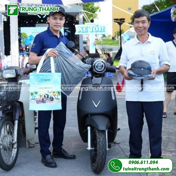 Nhân viên giao túi vải quà tặng của VinFast cho khách hàng